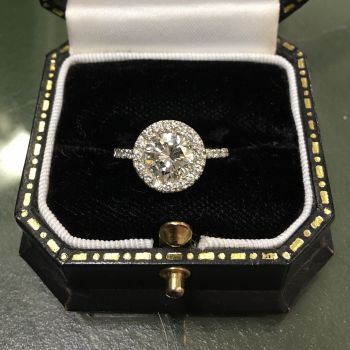 anello con diamante centrale e contorno in diamantini